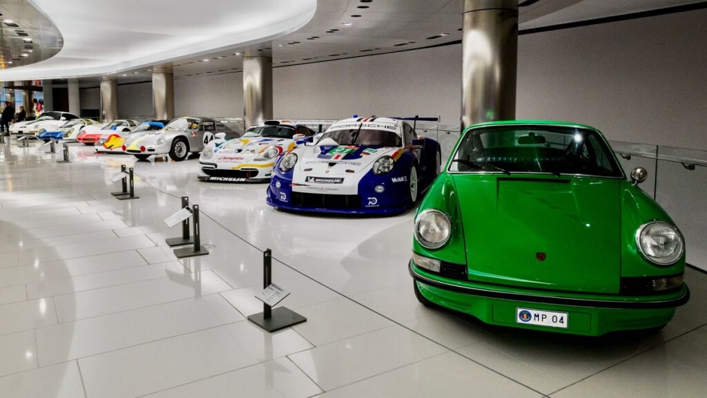Porsche car models and priceless race cars line a Monaco museum collection. 