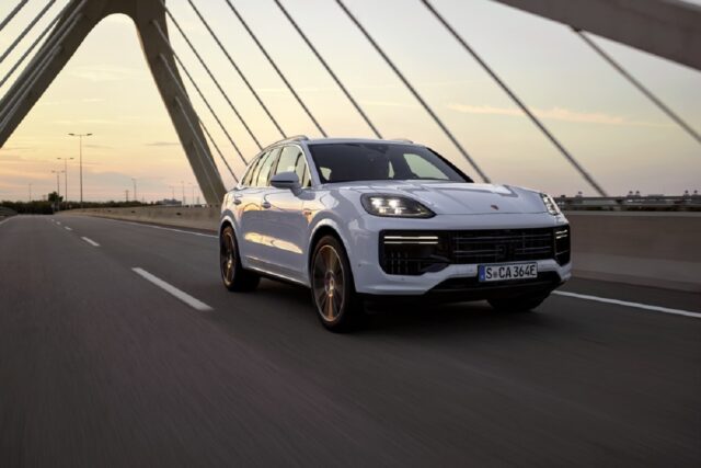 A white 2024 Porsche Cayenne E-Hybrid shows off its front-end styling.