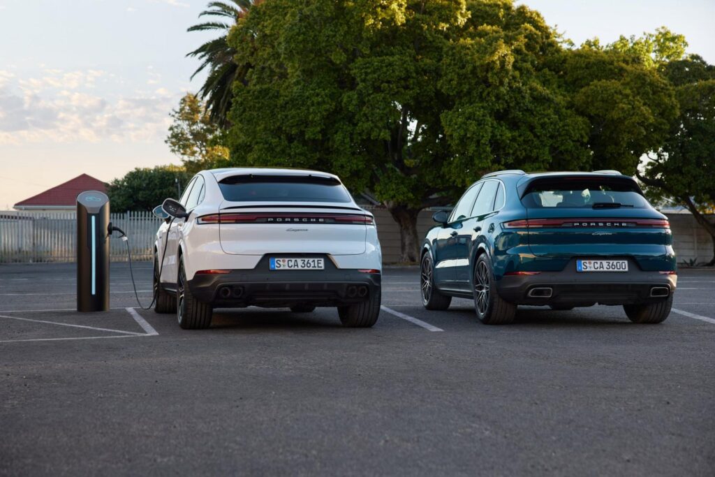 A set of 2024 Porsche Cayenne SUVs plugged in at charging stations.
